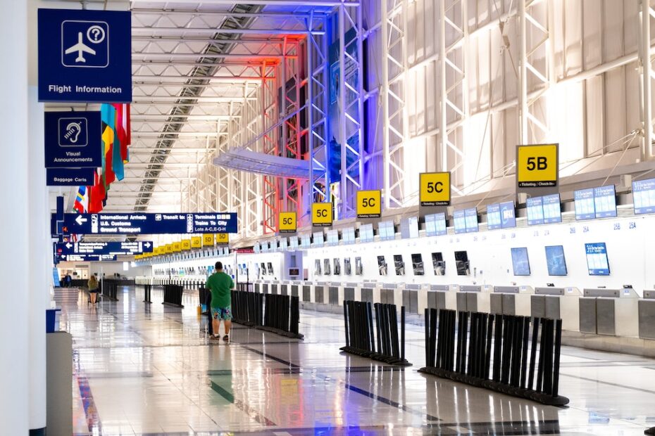 A person walking next to check in counters at an airport